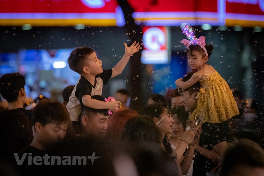Les enfants sont contents de sortir avec leurs parents et de découvrir l'atmosphère de la Fête de la mi-automne dans la rue Hang Ma.