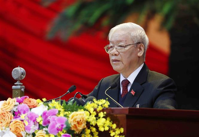 Le camarade Nguyen Phu Trong, secrétaire général du Parti et président du Vietnam, lit le Rapport politique du Comité central du Parti du 12e mandat et les documents soumis au 13e Congrès. Photo: VNA