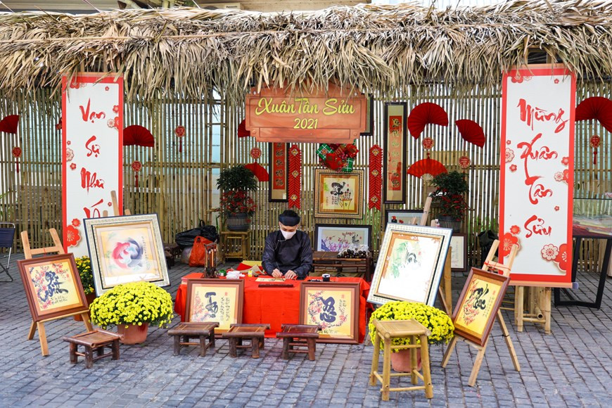 Un calligraphe dans la Rue du livre de Hanoï les premiers jours de la Nouvelle Année du Buffle 2021. Photo Vietnam +