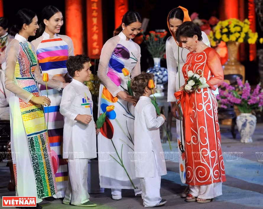 L'ambassadrice d'Italie au Vietnam, Cecilia Piccioni, porte un "ao dai" rouge du styliste Chu La, lors d'un défilé de mode au Temple de la Littérature Van Mieu- Quoc Tu Giam, à Hanoï. Photo: Vietnam Illustré