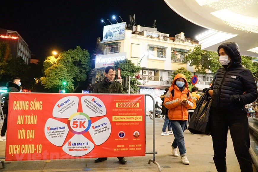 Les autorités délimitent les entrées pour les piétons. Une bannière est placée sur la barrière pour diffuser les mesures sanitaires 5K du ministère de la Santé (masques, désinfection, distance, pas de foule et déclaration médicale). (Photo: VNA)