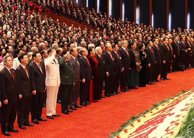 Les délégués participent à la cérémonie de salut au drapeau national. Photo: VNA