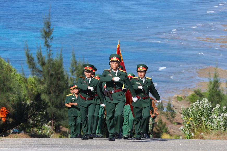 34 soldats de la Marine, des garde-frontières et des garde-côtes organisent une procession du drapeau national de 250m² au mât du drapeau au point culminant du mont Thoi Loi sur l’île de Ly Son.