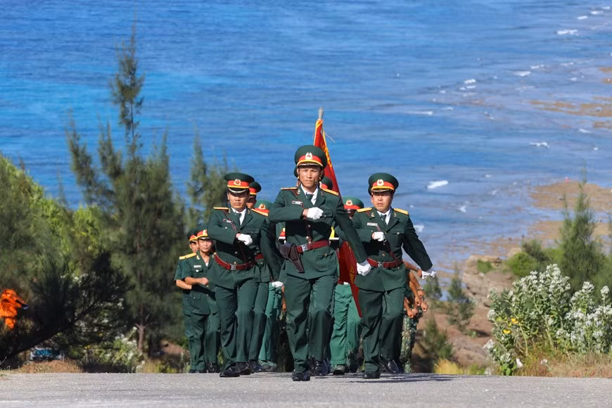 34 soldats de la Marine, des garde-frontières et des garde-côtes organisent une procession du drapeau national de 250m² au mât du drapeau au point culminant du mont Thoi Loi sur l’île de Ly Son.