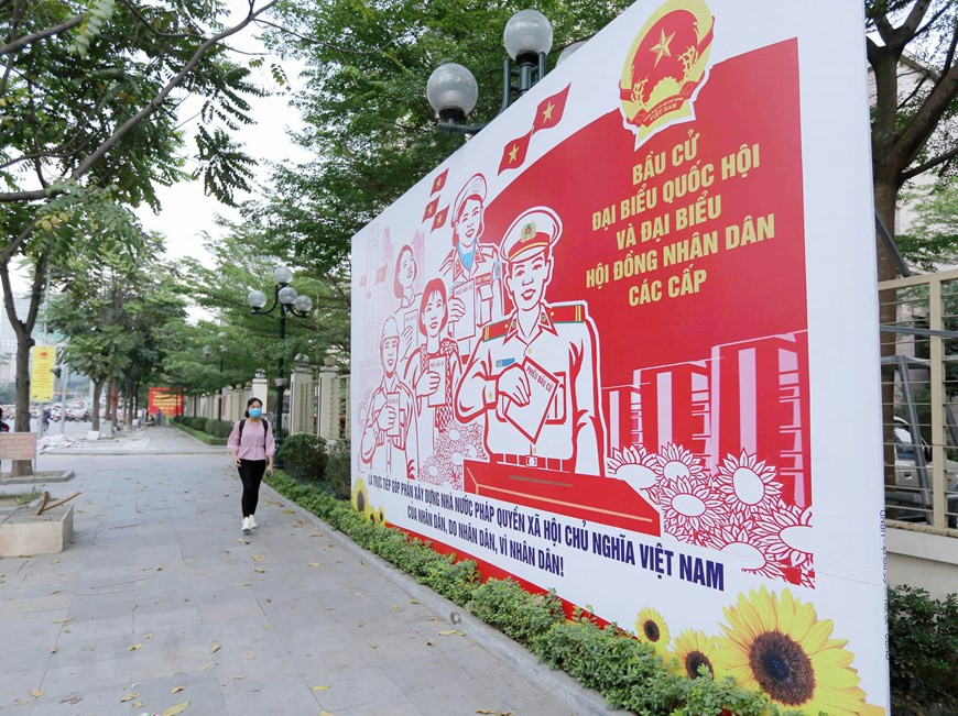  Un grand panneau d’affichage et des solgans le long de la rue Dai Co Viet. Photo : VNA