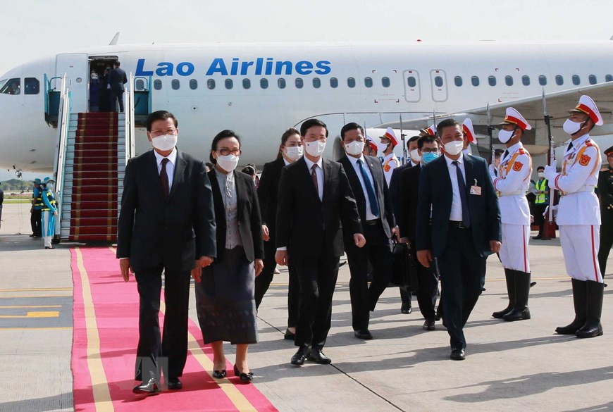 Vo Van Thuong, membre du Bureau Politique, secrétaire du Comité central du PCV, accueilli le secrétaire général du PPRL et président lao Thongloun Sisoulith et son épouse (gauche) à l'aéroport international de Noi Bai, à Hanoï. Photo: VNA