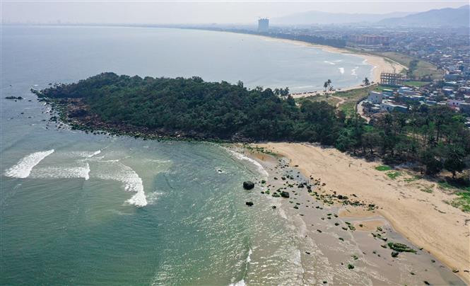 Les roches moussues du récif de Nam O apparaissent progressivement lorsque la marée baisse. Photo: VNA