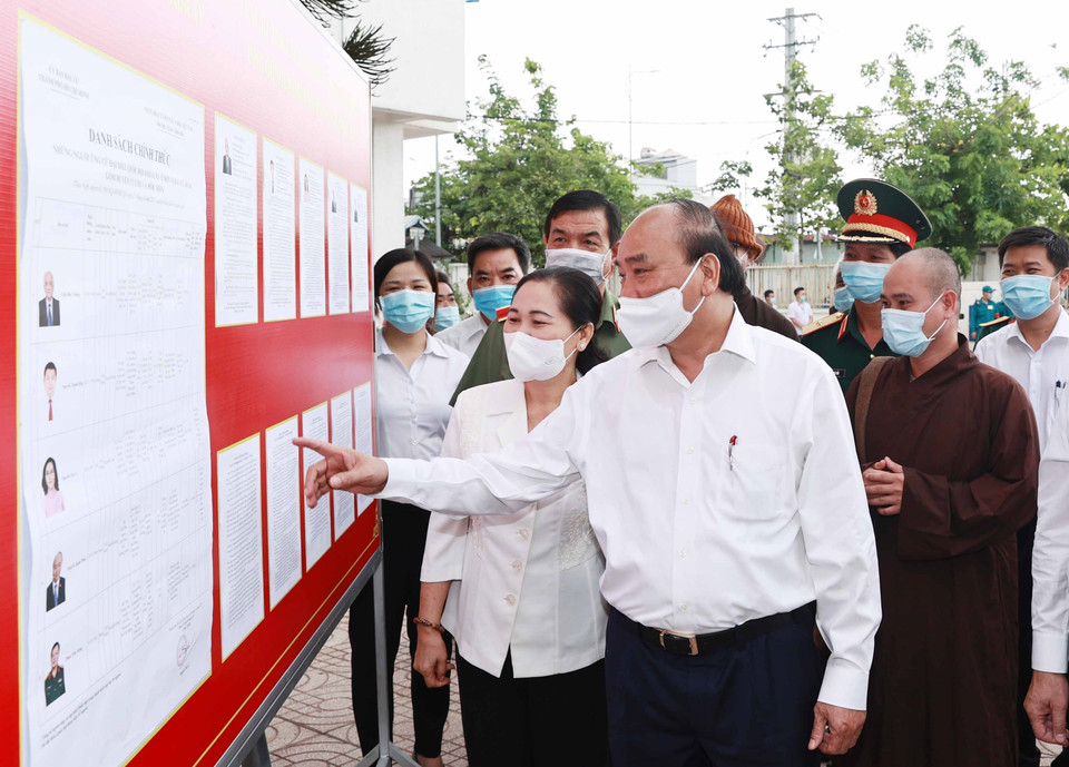 Le président Nguyen Xuan Phuc consulte la liste des candidats à la 15e Assemblée nationale répertoriés dans la commune de Trung Chanh, district de Hoc Mon. Photo: VNA
