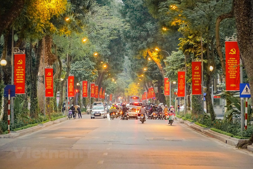 Les rues deviennent plus dynamiques et plus lumineuses que d'habitude avec des bannières rouges. Photo: Vietnam+