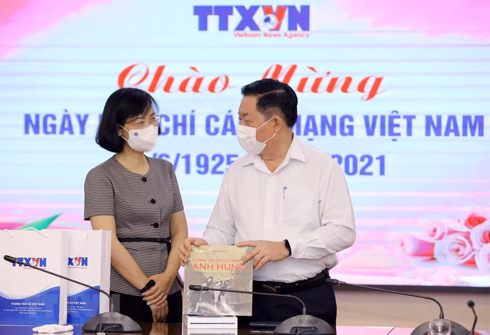 La directrice générale adjointe de la VNA, Vu Viet Trang, offre des livres de la VNA au chef de la Commission centrale de sensibilisation et d'éducation, Nguyên Trong Nghia.