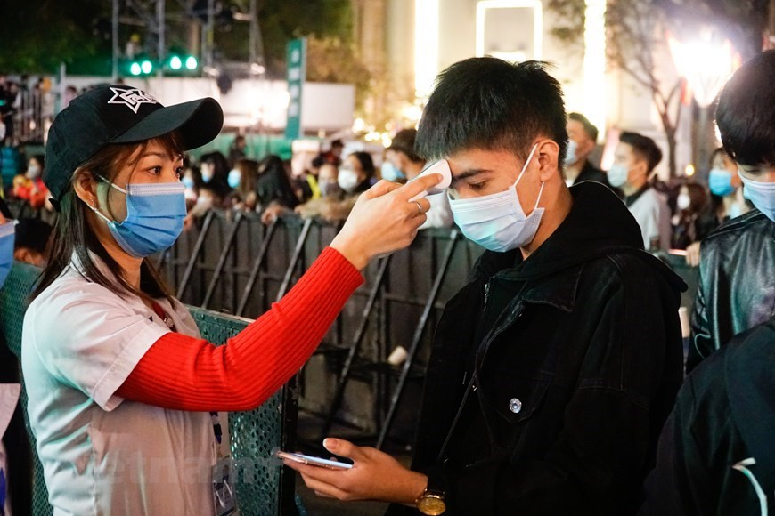 Mesurer la température corporelle d'un spectateur. (Photo: VNA)