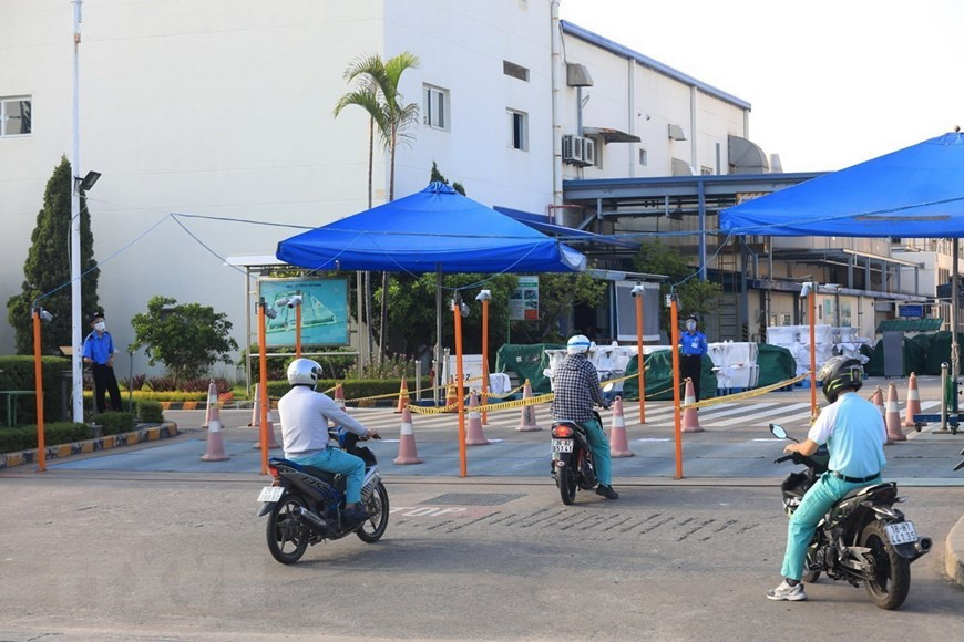 Les travailleurs venant travailler à la société TOTO Vietnam, dans la zone industrielle de Thang Long à Hanoï, doivent suivre des voies séparées. Photo: VNA
