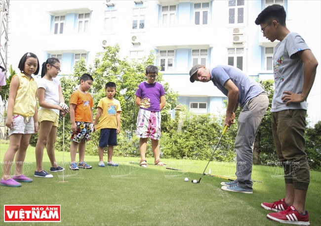 John McKenzie apprend aux élèves le bon usage d’un club de golf.
