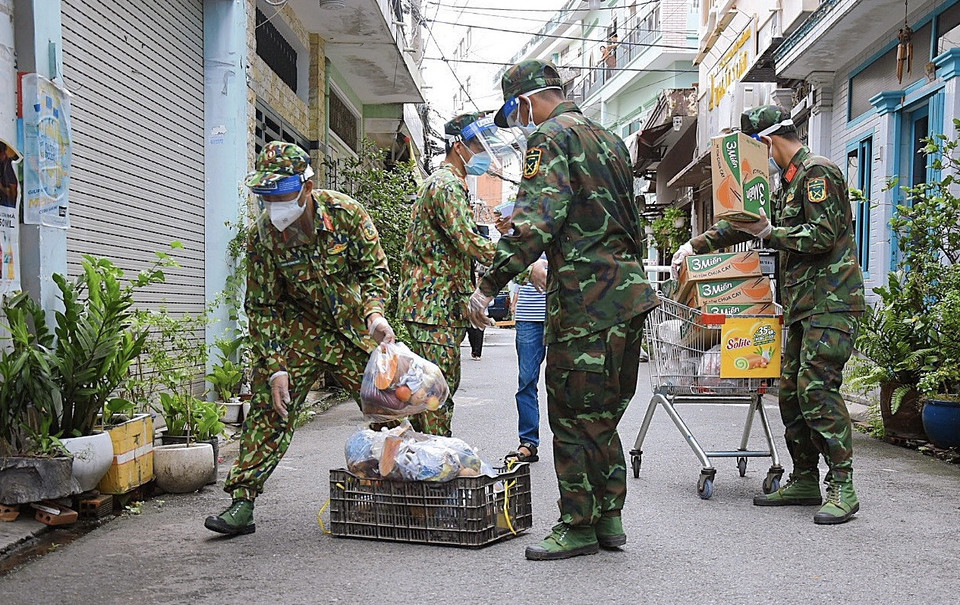 Des milliers de soldats sont chargés de distribuer des produits de base aux habitants des quartiers les plus touchés par le COVID-19 de la ville durant le confinement sévère qui leur interdit de sortir de chez eux pour même acheter de la nourriture. Photo: VNA