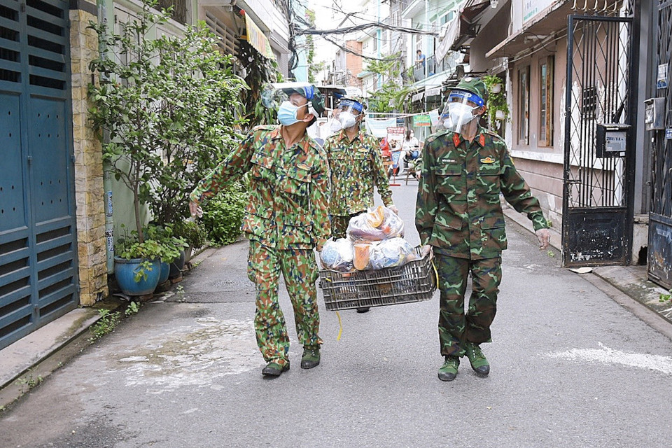 Des soldats distribuent des denrées alimentaires aux personnes dans le besoin. Photo: VNA