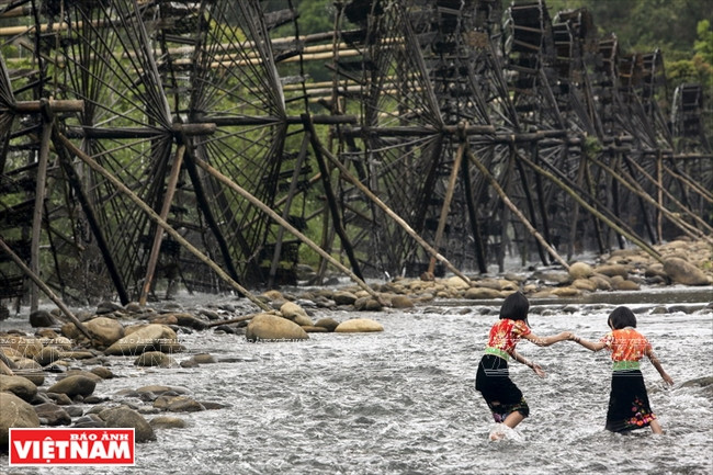 Ces enfants qui portent le costume traditionnel Thaï jouent dans les eaux fraîches de la rivière Nâm Mu.