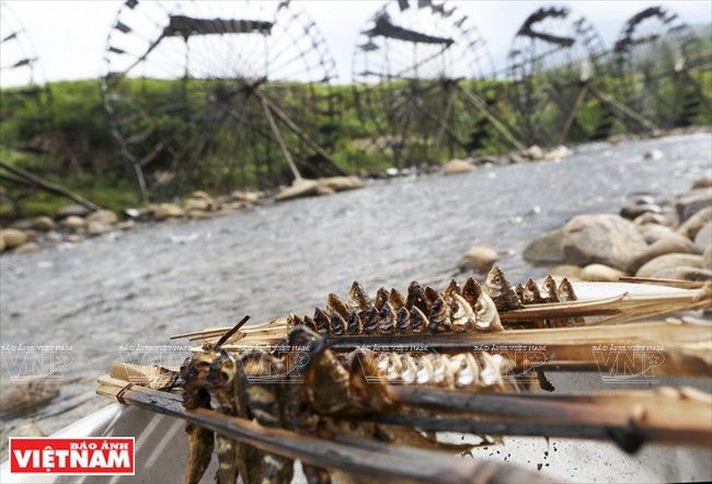Des touristes ​mangent le fruit de leur pêche directement au bord de la rivière.