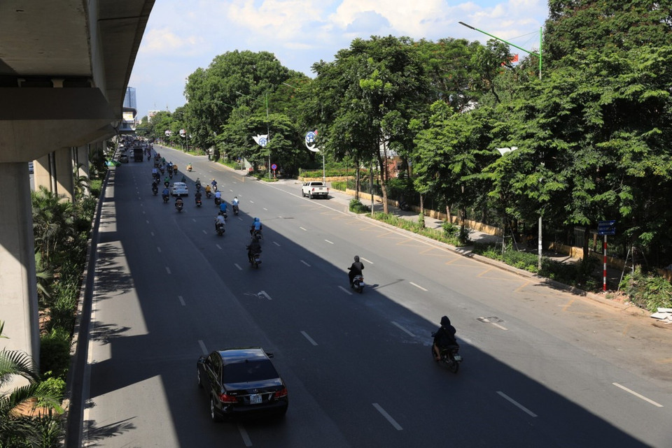 Des véhicules et personnes échappent à la chaleur à l'ombre de la voie ferrée aérienne Cat Linh - Ha Dong. Photo : VNA