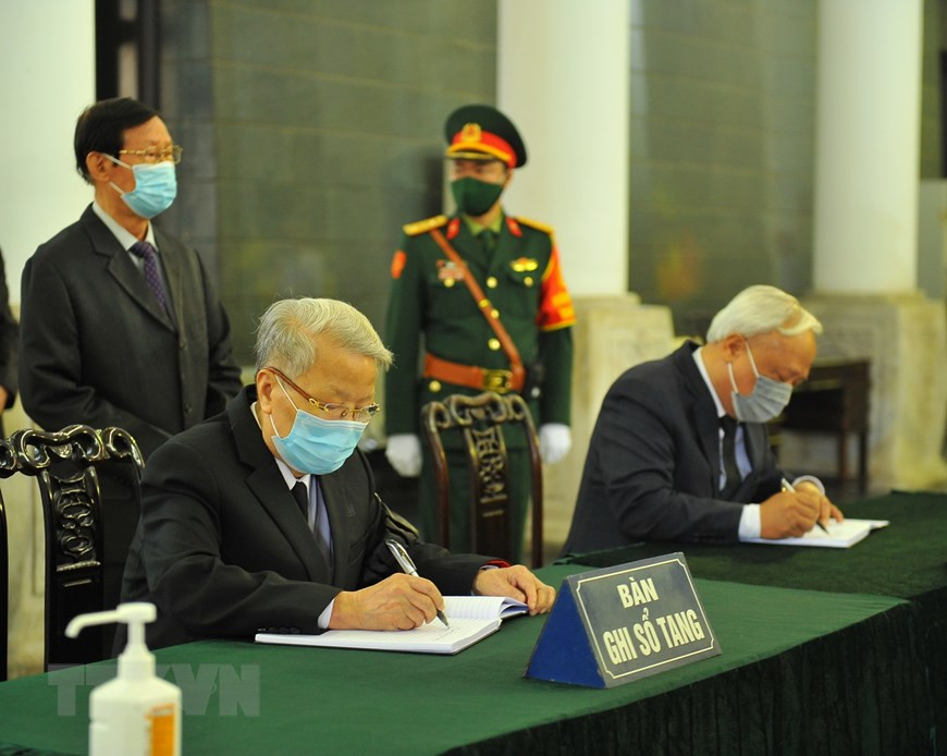 L'ancien président vietnamien Tran Duc Luong (gauche) et le vice-président de l'Assemblée nationale Uong Chu Luu écrivent le registre de deuil. Photo : VNA