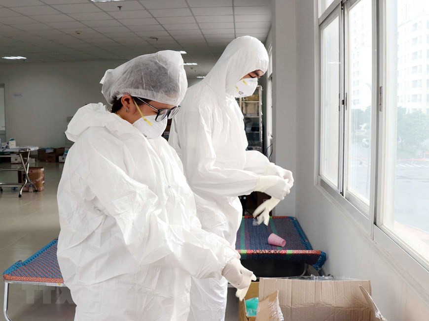 Vêtus de combinaisons de protection, portant trois gants pour chaque main, les médecins et infirmières sont prêts à prendre leur poste pour prendre en charge les patients infectés. Photo: VNA