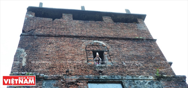 Un jeune homme essayant de prendre une photo de Danang à partir d'une fenêtre de la tour de Hai Vân Quan. 