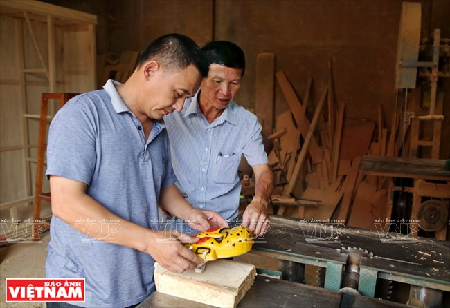  L’artiste Hung et un menuisier sculptent des masques pour les danseurs. 