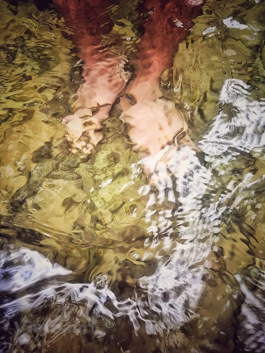 La meilleure saison pour profiter de la cascade de Khuoi Nhi se situe entre mai et juin, lorsque l'eau du lac est plus claire que jamais après les fortes pluies et que la cascade coule fortement. Après une journée de visite, il est reposant de s’attarder dans l’eau de la cascade et de se faire masser par de petits poissons dans le ruisseau. Les petits poissons, qui peuvent supporter de forts courants, ont une forme spéciale avec une tête pointue, un corps fin et une grande bouche. Ils mangent principalement de la mousse et des éphémères. Lorsque les touristes mettent leurs pieds dans l'eau, les poissons mordent doucement la peau morte, ce qui ressemble à un massage naturel. Photo: Vietnamplus