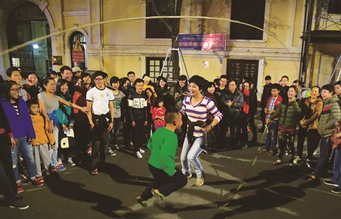 Une mère et son fils sautent à la corde, un jeu traditionnel qui retrouve une seconde jeunesse dans les rues piétonnes.