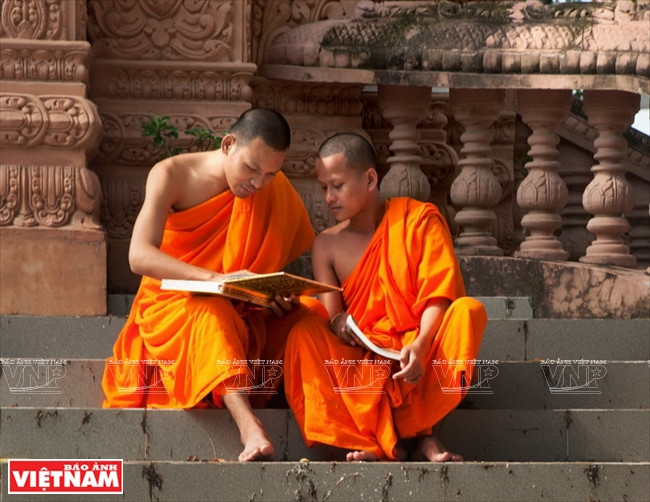 Deux jeunes bouddhistes révisent leurs leçons dans l’enceinte de la pagode.