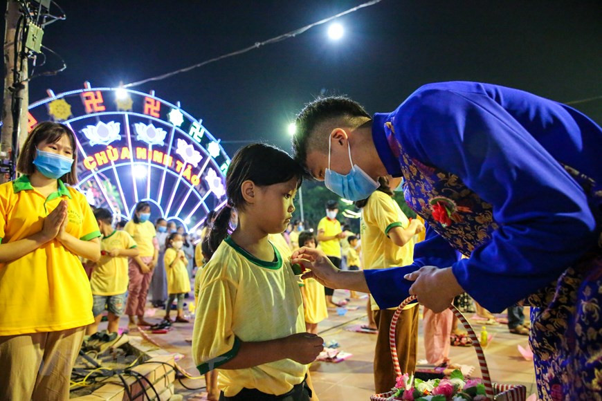 La rose est un symbole de la fête de Vu Lan. Tous ceux qui ont assisté à la cérémonie à la pagode de Ninh Tao ont été submergés d'émotions lorsqu'une rose est solennellement placée sur leur poitrine. Les rituels de la cérémonie de Vu Lan à la pagode de Ninh Tao sont brefs mais extrêmement solennels, respectueux et émotionnels. La manifestation a vu la participation de nombreux enfants qui accordent une attention particulière aux explications morales et sont venus à la pagode avec leurs parents et grands-parents. Tout le monde prie pour souhaiter de bonnes choses aux ancêtres ainsi qu’aux défunts isolés. Photo: VietnamPlus