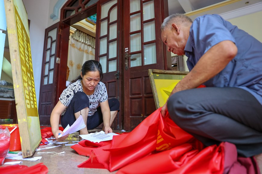 De nos jours, des technologies de pointe ont été utilisées pour fabriquer des drapeaux pour une productivité améliorée. Cependant, de nombreux ménages du village artisanal de Tu Van pratiquent encore la méthode traditionnelle de broderie. La famille de Vuong Thi Nhung en est un bon exemple, avec trois générations de fabrication des drapeaux nationaux brodés. Comme la méthode traditionnelle prend du temps et du travail, la plupart des drapeaux sont maintenant fabriqués avec des machines à broder. Mais les produits faits à la main possèdent toujours leur propre beauté et leur propre valeur. Tous les tailleurs aiment leur travail, le considérant comme un honneur. Photo: VietnamPlus