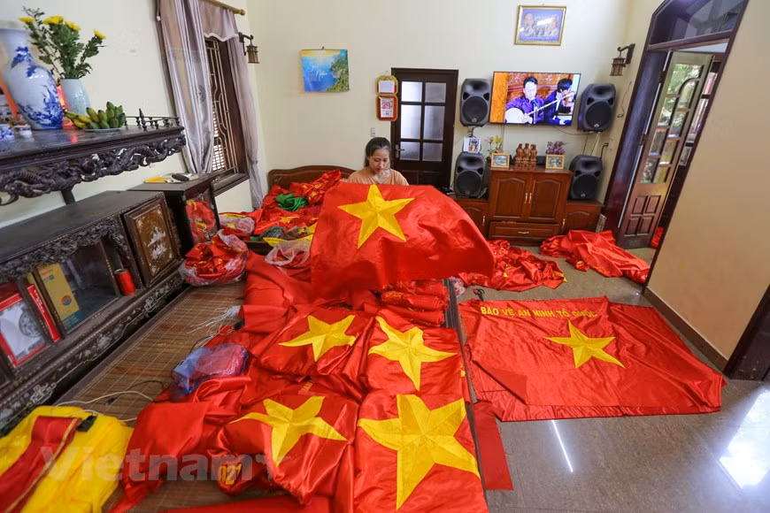 Les familles au village de Tu Van laissent leurs enfants se familiariser avec le métier quand ils sont petits, dans l'espoir de les rendre fiers de ce travail et de le transmettre à la génération suivante. La brodeuse chevronnée Vuong Thi Nhung a fièrement déclaré que sa fille n'avait que 23 ans maintenant, mais qu'elle avait plus de 11 ans d'expérience dans la broderie de drapeau. Selon Vuong Thi Nhung, la raison pour laquelle sa famille se concentrait sur l'artisanat au lieu d'utiliser des machines était le désir de persévérer dans le métier traditionnel de broder « l'esprit de la nation » pendant des générations. Photo: VietnamPlus