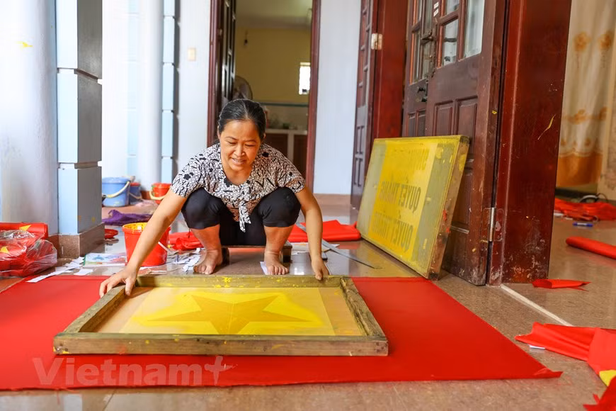 Vuong Thi Nhung, 46 ans, a passé plus de 30 ans à broder des drapeaux nationaux. Selon elle, les trois générations de sa famille ont brodé des drapeaux nationaux à Tu Van. Son père avait appris les techniques de fabrication de drapeaux pendant des années avant de les transmettre à sa progéniture. «Il y a des années, quand mon père était encore en vie avant de décéder à l'âge de 104 ans, il avait l'habitude de porter les drapeaux à nos clients dans la rue Hang Bong (arondissement de Hoan Kiem). Âgé de près d'un siècle à cette époque là, il pédalait pourtant sur des dizaines de kilomètres chaque jour. Il a été parmi les premiers à apporter le métier de broderie de drapeau à Tu Van, a déclaré fièrement Vuong Thi Nhung. Photo: VietnamPlus