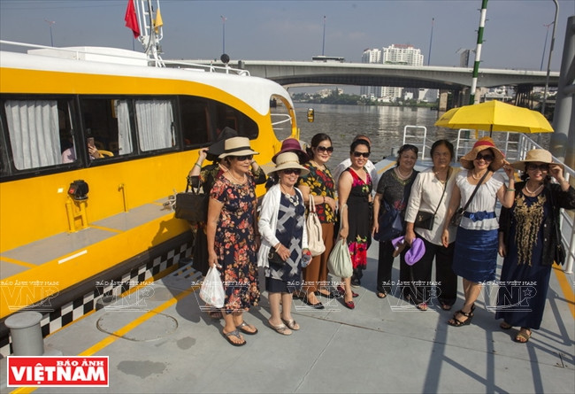 Des touristes posent devant un bateau-bus