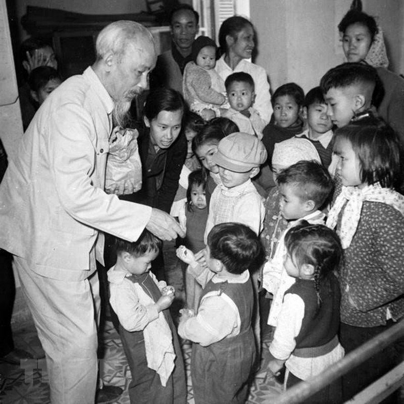 Le Président Ho Chi Minh donne des bonbons à des enfants d'ouvriers de l'usine de caoutchouc Sao Vang, de la savonnerie de Hanoï et de l'usine de tabac Thang Long, le 15 décembre 1961. Photo: Archives/VNA