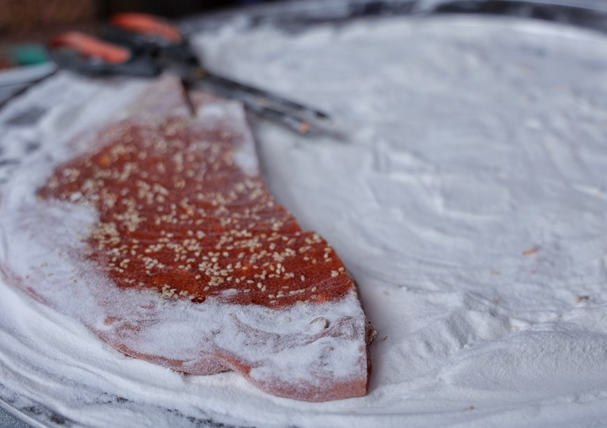 Une autre version du « che lam » avec des fruits « gac », qui présente une couleur rouge foncé, parmi ses ingrédients. La quantité de farine de riz dans le mélange est importante. S'il n'y a pas assez de farine de riz, le « che lam » sera très collant et mou. D'un autre côté, trop de farine de riz peut le rendre dur comme de la pierre. Une fois terminé, le mélange est versé sur un plateau de farine pour éviter qu'il ne colle au plateau et pour ajouter plus de parfum. Pour le «che lam» à feuilles de pandan, les feuilles sont bouillies et l'eau est ajoutée lors de la préparation du mélange. Pour le «che lam gac», la chair du fruit doit être cuite avant d'être ajoutée au mélange. Photo: Vietnamplus