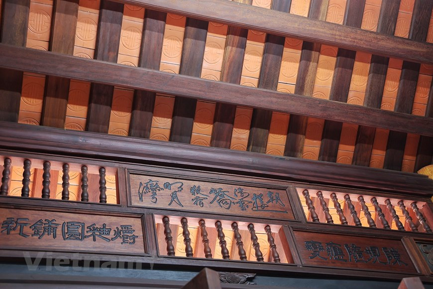 En regardant la maison, on est attiré par son toit de tuiles traditionnelles, des sentences parallèles et les dessins stylisés sur les deux côtés. La pente du toit est calculée en tenant compte des caractéristiques climatiques de la région. L'habitation garde un climat frais pendant la touffeur estivale. Les piliers sont placés sur le piédestal de forme carrée. Les architectes portaient-ils tous leurs efforts sur les piliers et la charpente, fixés avec deux chevilles (sans clou). Le système de chevrons est sculpté de délicats motifs décoratifs. La maison traditionnelle à cinq compartiments fait partie de l'architecture unique trouvée dans le delta du fleuve Rouge. Son propriétaire est l'artisan émérite Tran Nam Tuoc qui souhaite préserver les valeurs traditionnelles mais qu'en même temps apporter des modifications pour créer un espace de vie pour sa famille. Photo: Vietnamplus