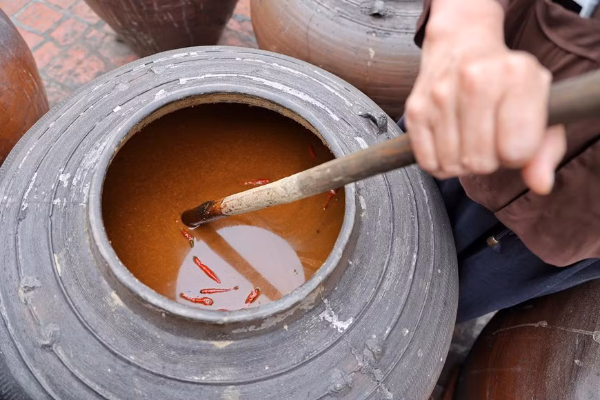 Personne à Duong Lam n'a la moindre idée de la date de production de la première sauce soja dans le village. La sauce est produite à partir de riz gluant, de soja, de maïs et de sel à l'aide de mortiers en pierre, de casseroles en cuivre, de cuiseurs vapeur, de poêles à frire, de paniers et de bocaux. Les fabricants de sauce soja choisissent très soigneusement leurs matériaux. Ils font de la sauce soja principalement en mai et juin car cette période de l'année est optimale pour le travail. Les villageois de Duong Lam continuent de faire de la sauce soja à la main et, pour eux, l'eau de pluie est un ingrédient indispensable. Photo: Vietnamplus