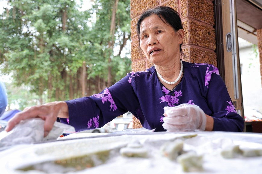 De nos jours, les habitants de Duong Lam ont mis au point plusieurs nouvelles variantes de « che lam » en ajoutant des ingrédients comme des fruits « gac » et des feuilles de pandan, le rendant plus parfumé, coloré et savoureux. Cette photo montre « che lam » avec sa couleur verte provenant de feuilles de pandan. Le riz destiné à la fabrication du « che lam » est le riz gluant à fleur d'or, l'une des meilleures variétés du Vietnam, cultivé uniquement dans le Nord. Tout d'abord, le riz est rôti et moulu en une farine lisse. Ensuite, il est cuit avec de l'eau, du sucre et du gingembre, en remuant continuellement pour obtenir le mélange épais. Lorsque le mélange est encore chaud, des cacahuètes sont ajoutées pour lui donner un goût beurré et croquant. Photo: Vietnamplus
