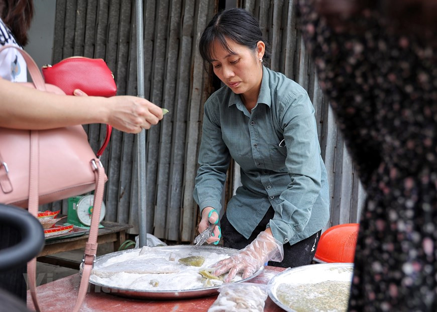 Toutes les étapes pour faire du « che lam » prennent environ 10 minutes. La dernière chose à faire est de saupoudrer de sésame grillé sur le dessus. Après avoir laissé le mélange refroidir pendant une heure, il est prêt à être servi. Un bon «che lam» est un peu doux et moelleux, légèrement sucré et gingembre, portant les saveurs parfumées du pandan ou du gac, ainsi que la richesse des arachides. La façon unique d'en faire remonte à quelques centaines d'années. Il est préférable de profiter du « che lam » par une journée venteuse, lorsque le temps commence à se refroidir, avec du thé vert chaud pour l'accompagner. Photo: Vietnamplus