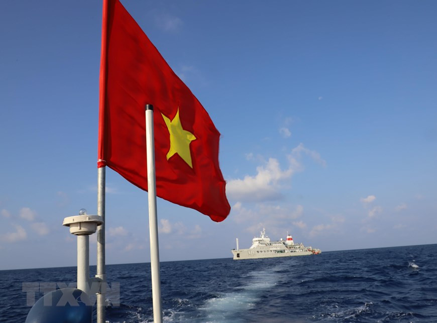 Le drapeau national flotte sur le toit d'un bateau à moteur transportant des fonctionnaires et des soldats du navire Truong Sa 571 à l'île de Song Tu Tay.
