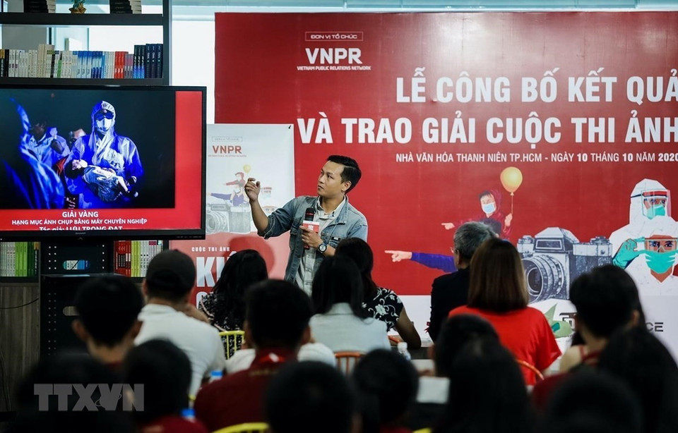  Le photographe Luu Trong Dat de la VNA présente son œuvre primée au concours photographique « Kien Cuong Viet Nam ». Ce concours a été organisé par le réseau Vietnam Public Relations Network pour diffuser des images impressionnantes sur la lutte contre le COVID-19. Photo : VNA