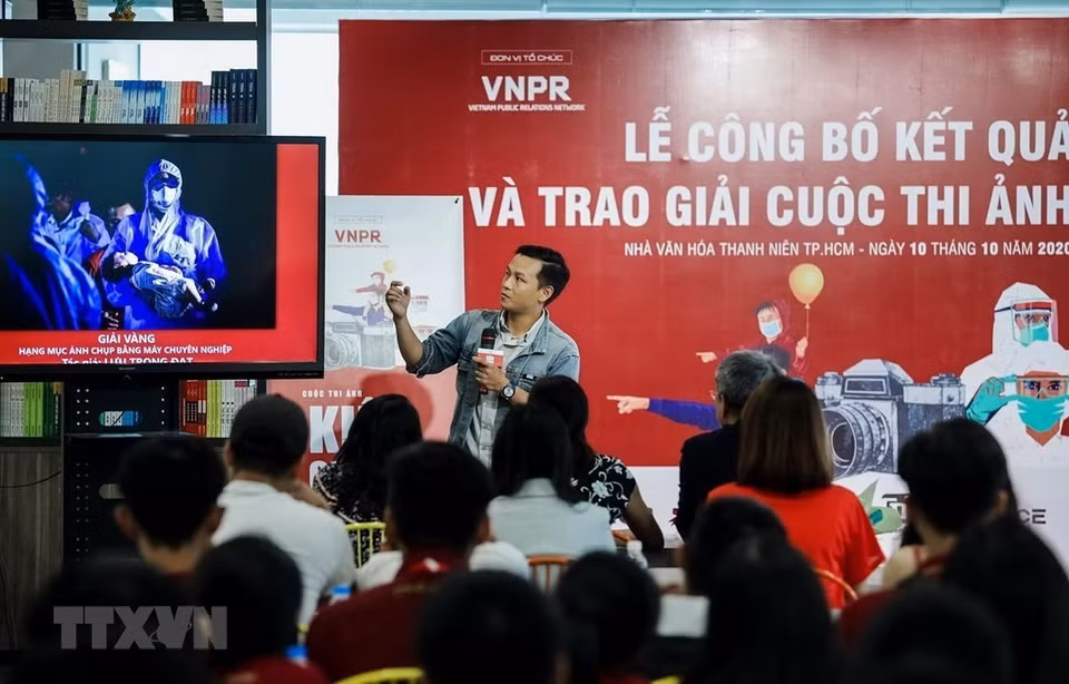  Le photographe Luu Trong Dat de la VNA présente son œuvre primée au concours photographique « Kien Cuong Viet Nam ». Ce concours a été organisé par le réseau Vietnam Public Relations Network pour diffuser des images impressionnantes sur la lutte contre le COVID-19. Photo : VNA