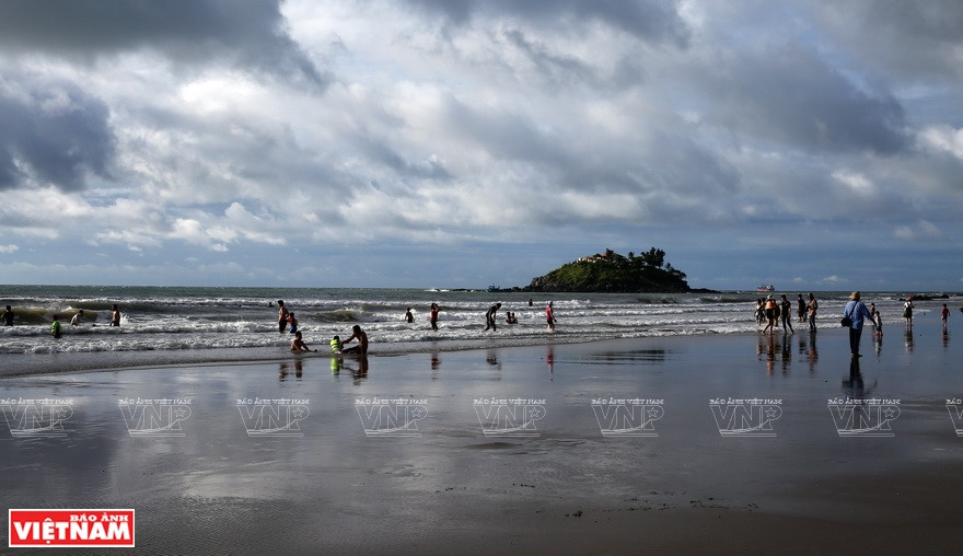 Les visiteurs admirent le lever du soleil à la plage de Bai Sau.