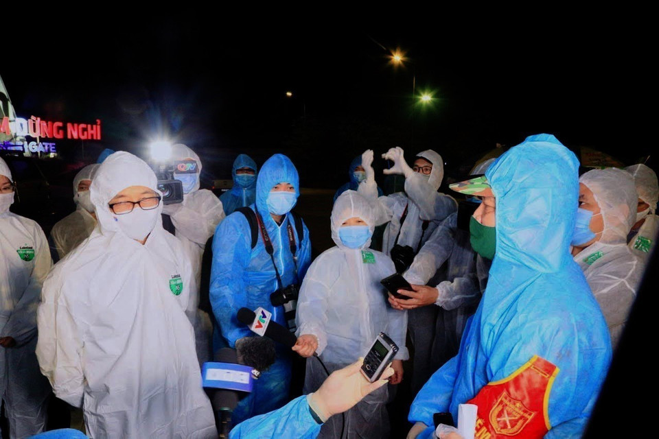 Des journalistes travaillent lors de la tournée du vice-Premier ministre Vu Duc Dam dans la ville de Dong Trieu (à Quang Ninh) pour contrôler la prévention du COVID-19. Photo : VNA 