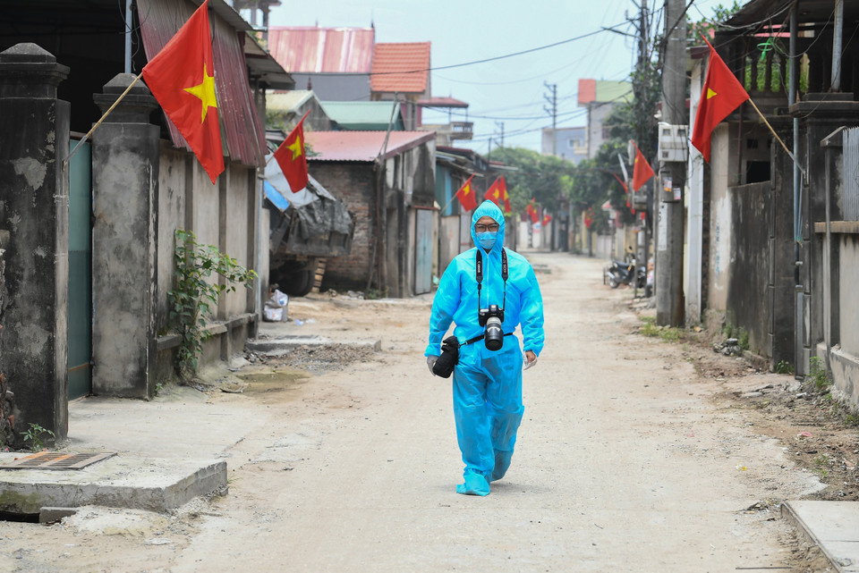 Le photographe Thanh Dat de la VNA en mission dans la zone épidémique du hameau de Lo Giao, district de Dong Anh, Hanoï. Photo : VNA 