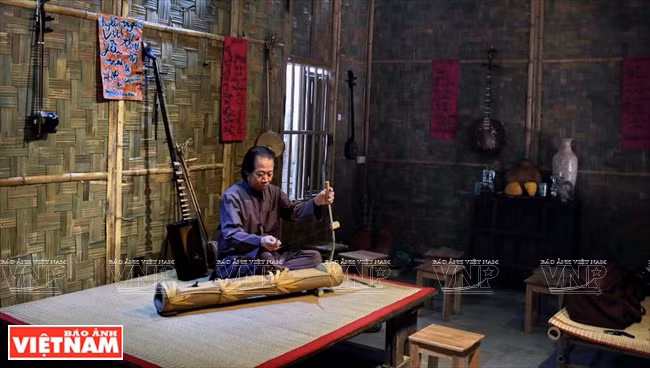 Xuân Hoach jouant, chez lui à Hanoi, sur des instruments traditionnels.