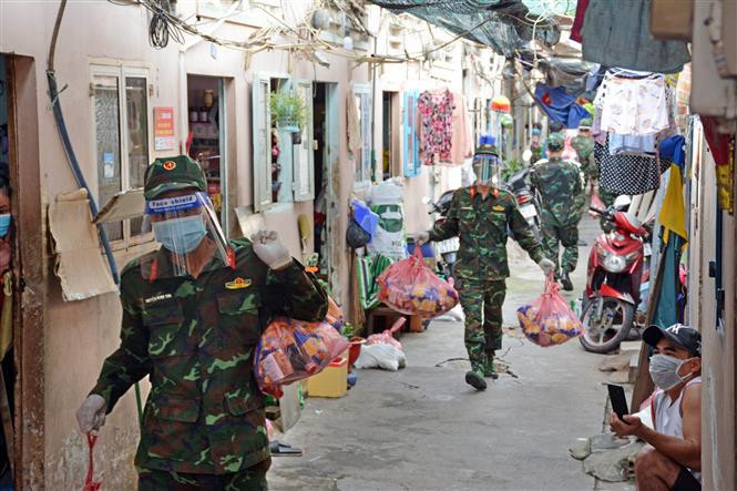 Des officiers et soldats du régiment 31, division 309, corps No4, livrent des cadeaux dans des zones épidémiques du 16e quartier du 8e arrondissement, à Ho Chi Minh-Ville . Photo: VNA