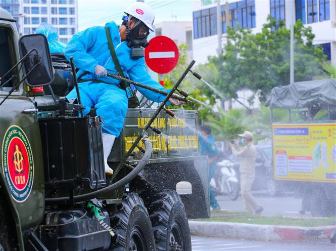 Des soldats de l’Armée chimique du ministère de la Défense, pulvérisent du désinfectant sur certaines rues et zones à risque élevé d'infection au COVID-19 dans le district de Son Tra, ville de Da Nang. Photo: VNA