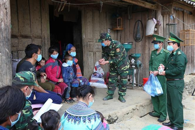 Des officiers et soldats du poste-frontière de Pha Long et des gardes-frontières de Lao Cai expliquent les mesures de prévention contre le coronavirus à des minorités ethniques. Photo: VNA